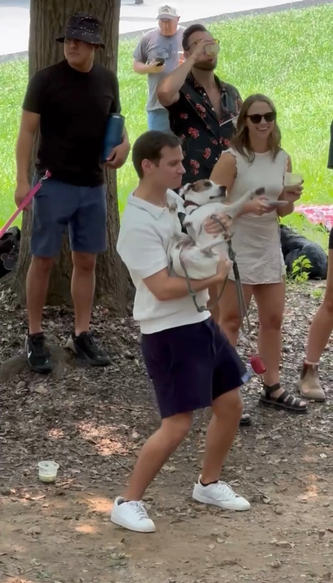 Guy holding dog at park hangout
