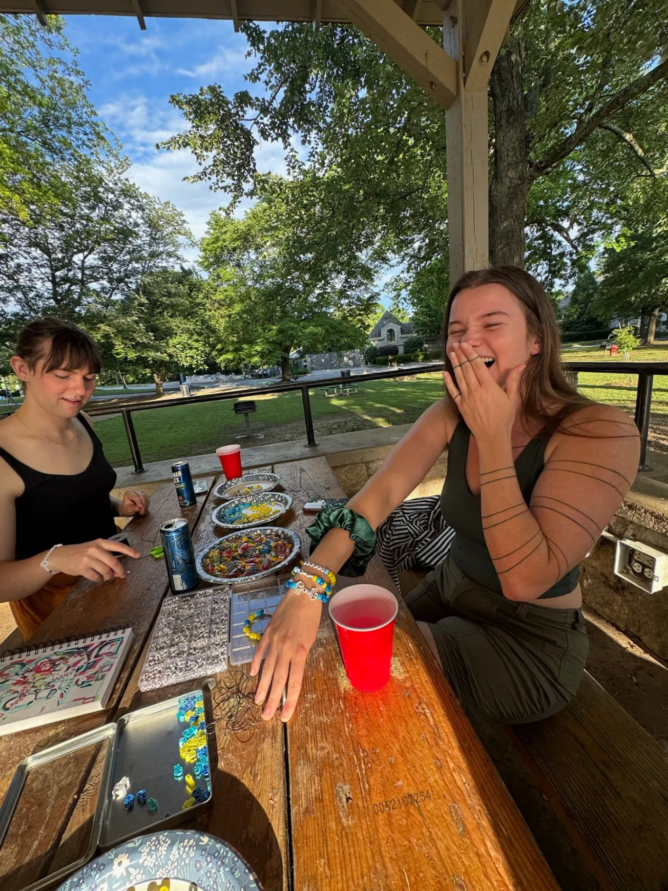 Friends laughing making bead bracelets